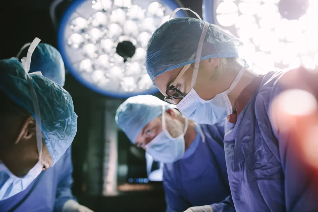 A team of surgeons collaborates in a sterile operating room, focused on a surgical procedure.